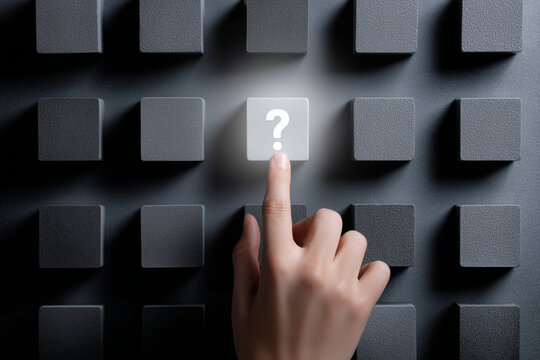 Hand pressing illuminated square button with question mark symbol among dark blocks, concept of choice and uncertainty