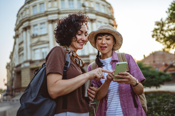 two women use mobile phone for directions walk and touring city