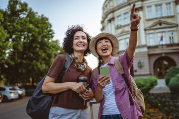 two women use mobile phone for directions walk and touring city
