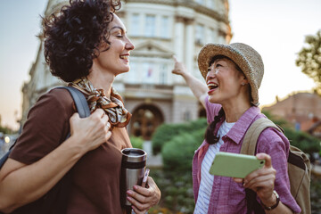 two women tourist use map on mobile phone to find destination location