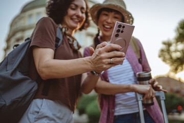two women use mobile phone for directions walk and touring city