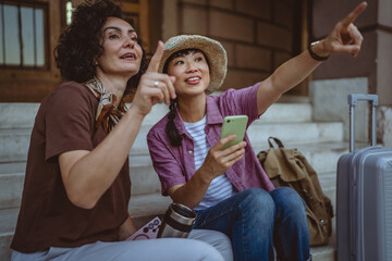 female tourist use mobile phone for directions while sit on staircase