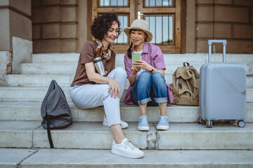 female tourist use mobile phone for directions while sit on staircase