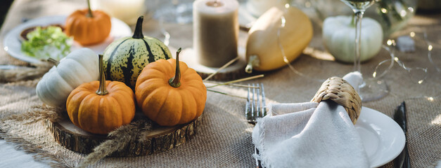 Fall table decoration with pumpkins, wine. Family thanksgiving dinner arrangement outdoors in the...