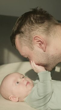Three month old baby boy playing with father close up. Tender family morning in warm sunlights. Happy Parenthood. Unconditional Love of Dad and Child