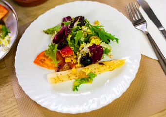 Traditional Spanish mixed salad, made from corn, tomato, lettuce, olives, asparagus, bell peppers on table