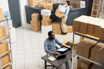 Black warehouse worker handling cargo and shipping logistics, coordinating inventory and hand...