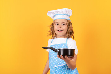 Kid chef cook with cooking pot stockpot. Chef kid boy making healthy food. Portrait of little child...