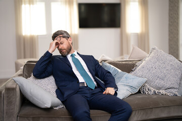 Headache, tiredness and stress. Business man in suit uses a laptop, is tired got headache migraine....