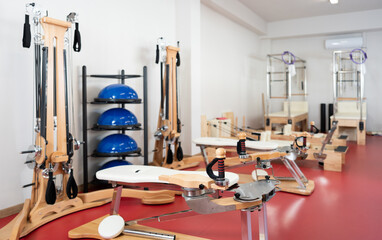 In modern gym there is equipment for Pilates training -reformer bed, multifunctional bench, pilates...