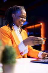 Happy african american girl excited to do internet shopping, typing debit card information on...