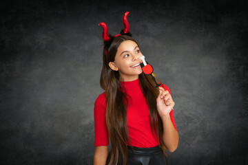child girl with devil horns hold cocktail on Halloween party. Halloween witch teen girl. Little...