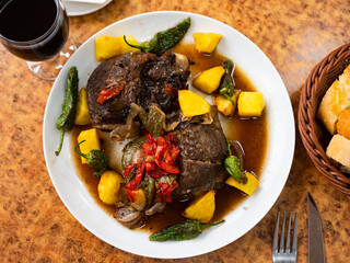 Appetizing pork cheeks baked with potatoes served on platter
