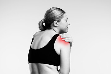 Woman experiencing shoulder pain in black and white image