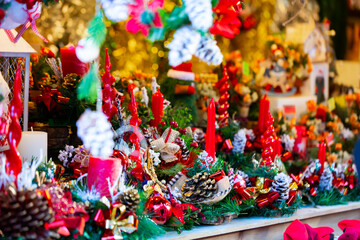 Decorated shopping stands with Christmas candles, fir trees and pine cones at outdoor Xmas fair