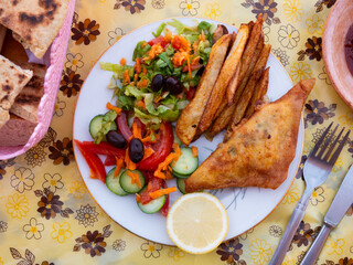 Appetizing tunisian dish pie brik served with vegetable salad on platter