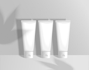 Three tubes of cream with shadows on a gray background. Vector mockup of cream tubes.