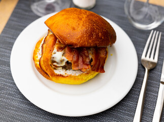 Tasty hamburger with cutlet, cheese and bacon closeup