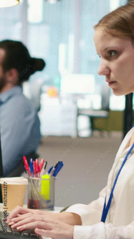 Poster vertical video female programmer in startup office struggling to fix application errors while coding