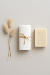 Natural spa essentials flatlay with towel, soap, and dried flowers