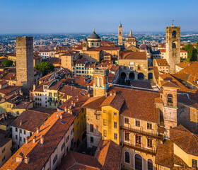 Fototapeta premium Aerial view of Bergamo’s Città Alta in Italy with terracotta rooftops, historic churches, and mountain backdrop