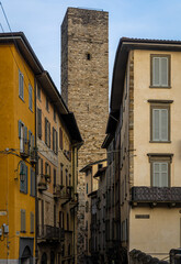 Streets of Bergamo’s Città Alta in Italy with terracotta rooftops, historic churches, and mountain backdrop on a clear day