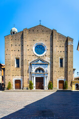 Narrow street view in Salo, Italy with colorful buildings leading to a historic church facade featuring a large circular stained-glass window