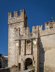 Aerial view of historic Scaliger Castle in Sirmione, Italy, surrounded by mountains