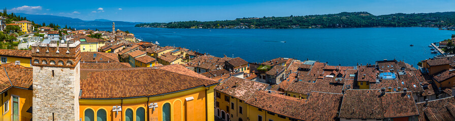 Aerial view of Salo, Italy with terracotta rooftops, lakeside promenade, and boats docked on the...