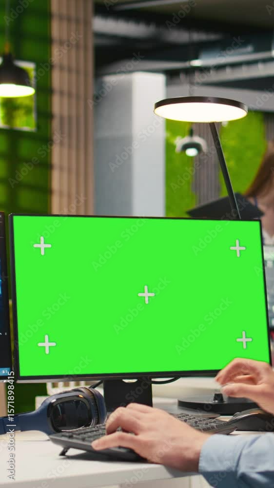 Poster vertical video technician in office using green screen pc, automating repetitive tasks with ai scrip