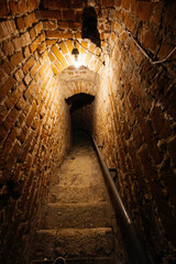 Arched narrow passage with spiral stairs