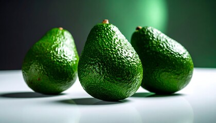 Three Ripe Avocados on a White Surface with Dark Green Background