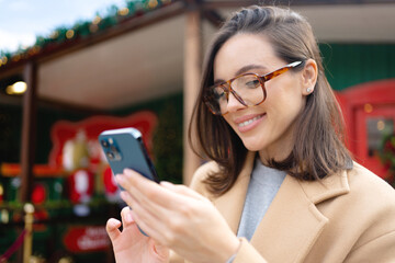 Happy, excited woman with smartphone outdoor for text message, notification and social media news. Deal, winner and celebration with girl on yellow background for offer, giveaway and surprise