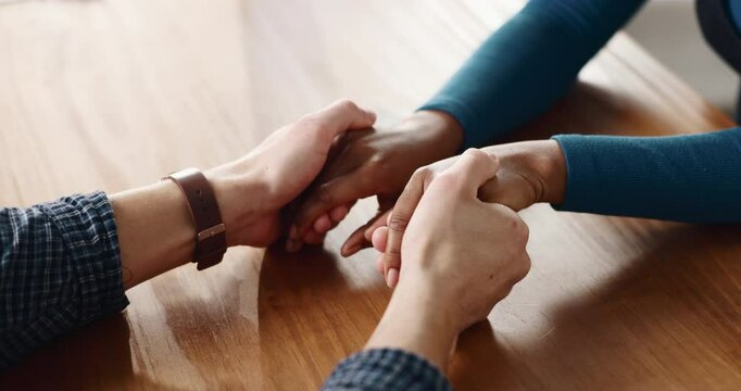 Therapy, support and couple holding hands on table for love, apology and trust in home. Forgive, kindness and people bonding together for empathy, partner and commitment for relationship and care