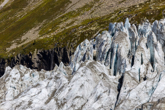 Glacier Argentiere in Chamonix valley, french Alps. Blue ice in a glacier serac and crevasse in the alpine scenic landscape in summer. Aiguille du Chardonnet mountain summit peak above the glacier