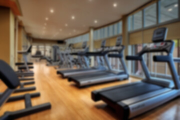 blurry gym scene, lots of gym equipment lined up neatly, modern theme without any people, bright light, blurry gym background.