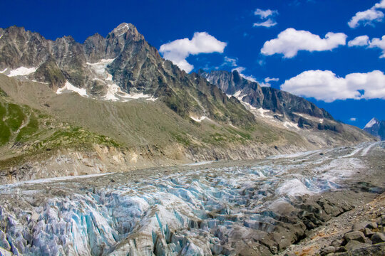 Glacier Argentiere in Chamonix valley, french Alps. Blue ice in a glacier serac and crevasse in the alpine scenic landscape in summer. Aiguille du Chardonnet mountain summit peak above the glacier
