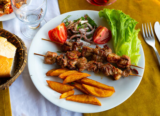 Lamb shish kebab with lettuce, tomatoes and French fries. Turkish cuisine