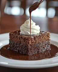 Chocolate brownie dessert with whipped cream and chocolate sauce