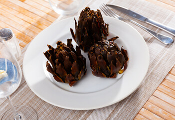Baked artichokes with spices on plate, tasty vegetables for dinner