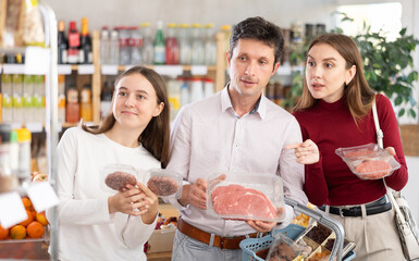Couple adult man and young woman with teenage daughter buy hamburger patty or beef entrecote in...