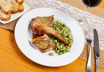 Roasted rabbit with crispy golden brown coating and green mung beens as side disch
