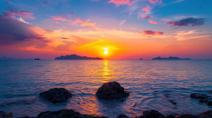 The sun is setting over the ocean, casting a warm glow on the water