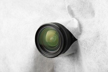 Hidden camera lens through torn hole in white fabric