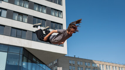 A girl jumps on an outdoor trampoline.