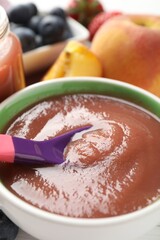 Baby food. Eating tasty puree with spoon at table, closeup