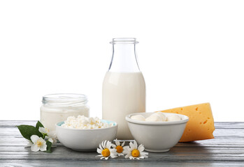 Different fresh dairy products and flowers on grey wooden table against white background