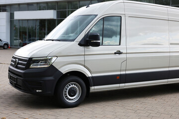 One white minibus parked on paved road outdoors