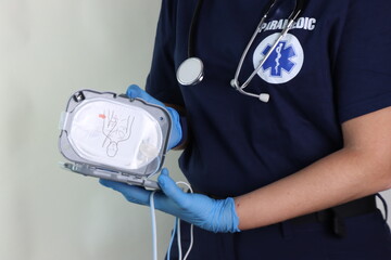 Paramedic holding a defibrillator pads in the hands to rescue in an emergency