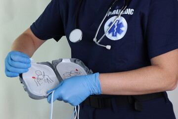 Paramedic holding a defibrillator pads in the hands to rescue in an emergency